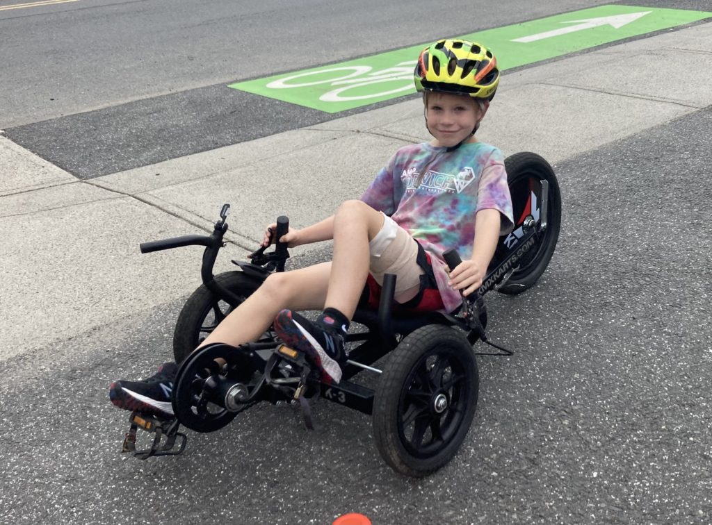 Image shows a young child riding a small black trike